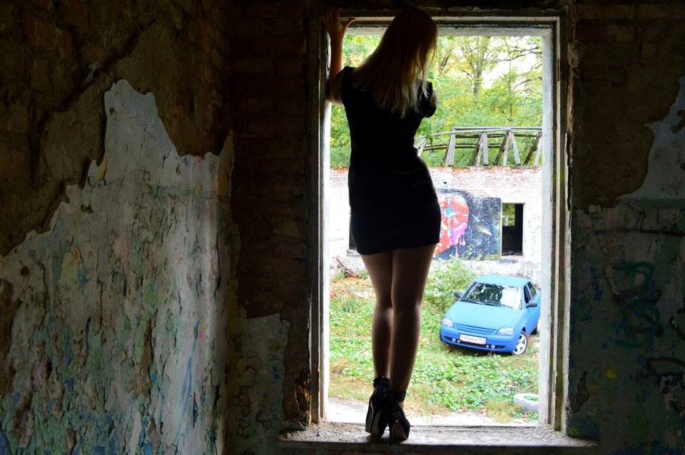 Откровенная блондинка позирует на фоне заброшенного здания