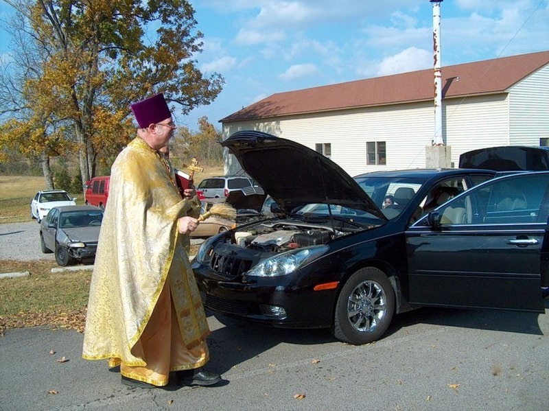 Священник освящает машину