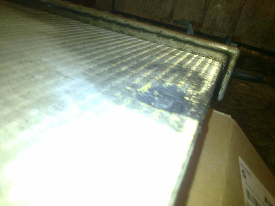 Плохо видно, на радиаторе некая выбоина в результате свободного перемещения того самого бочёнка. Он просто-напросто замял радиатор по своей форме — Opel Astra G