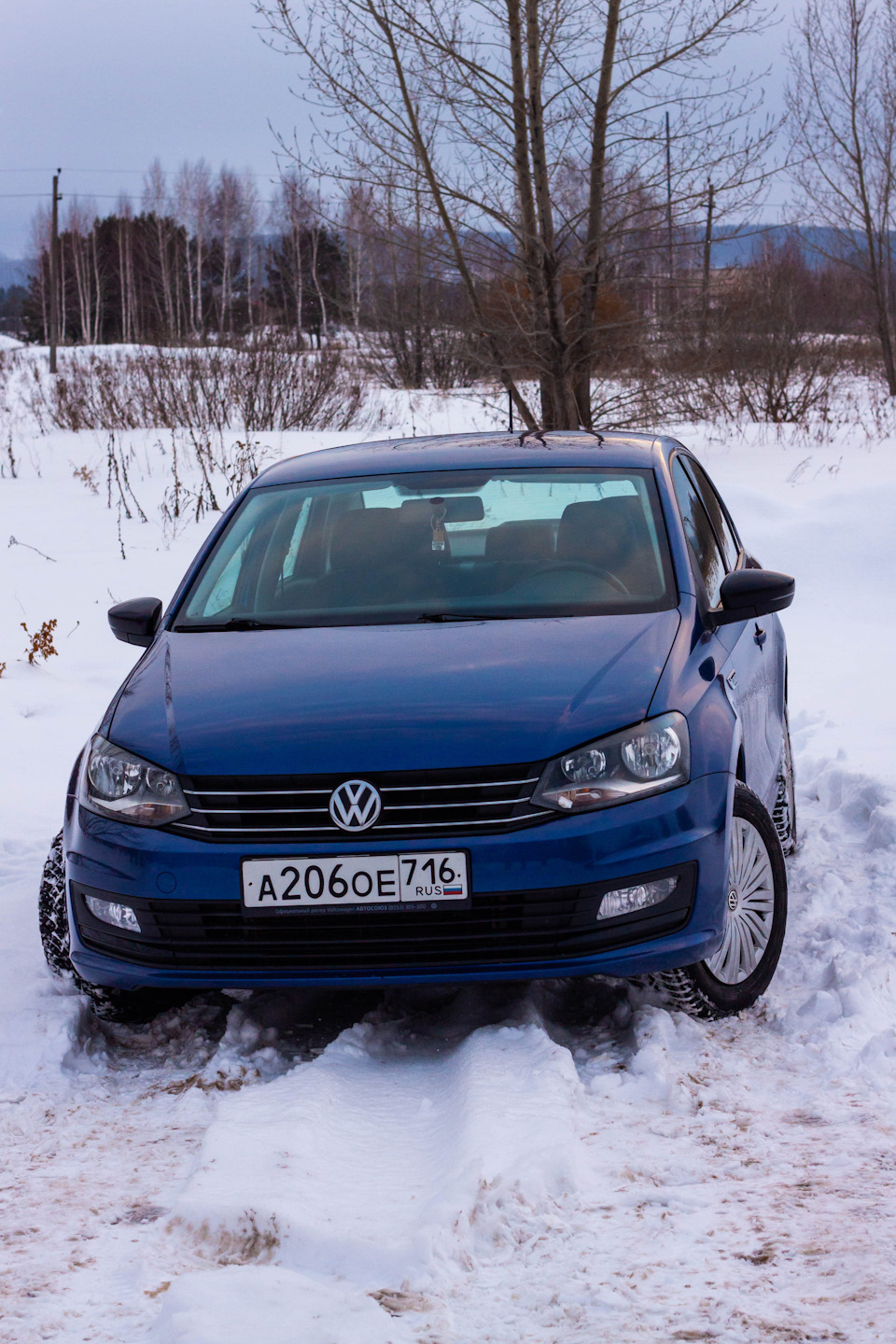 Белый седан Volkswagen Polo зима