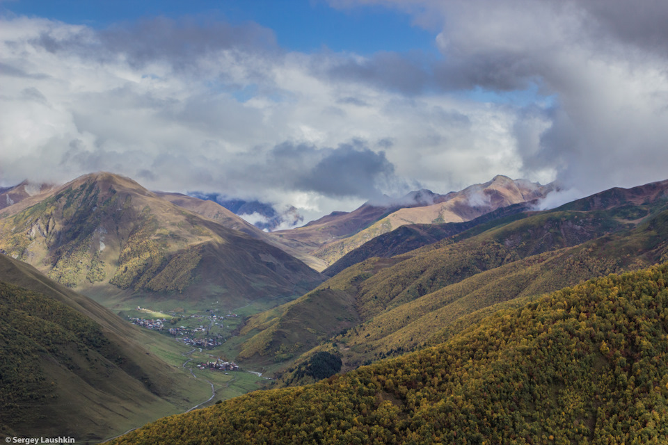 Вид с вершины перевала Латпари в облачную погоду. Внизу расположен поселок Ушгули. — Mitsubishi Pajero Sport (2G)
