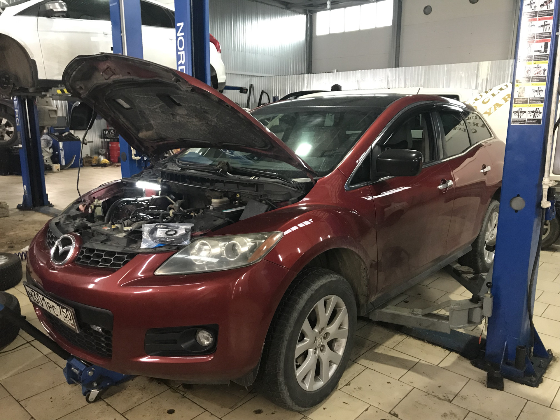 Ремонт мазда. Mazda cx7 сервис. Мазда сх7 на подъемнике в сервисе. Мазда СХ-7 В сервисе. Техобслуживание Мазда CX 7.