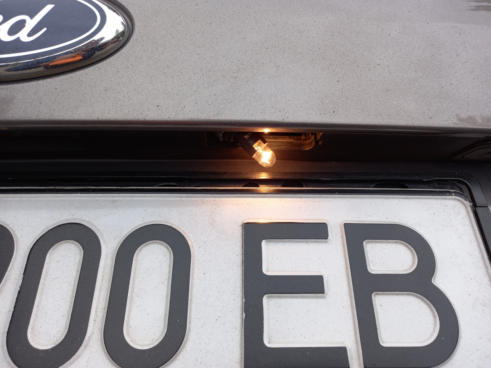 Купить номера на форд. Замена ламп освещения номерного знака Форд Куга 2. Замена лампочки подсветка номерного знака Форд Транзит с 2015 года. Замена лампы подсветки номерного знака Форд Куга 2. Замена ламп подсветки номера Форд Транзит 2012.