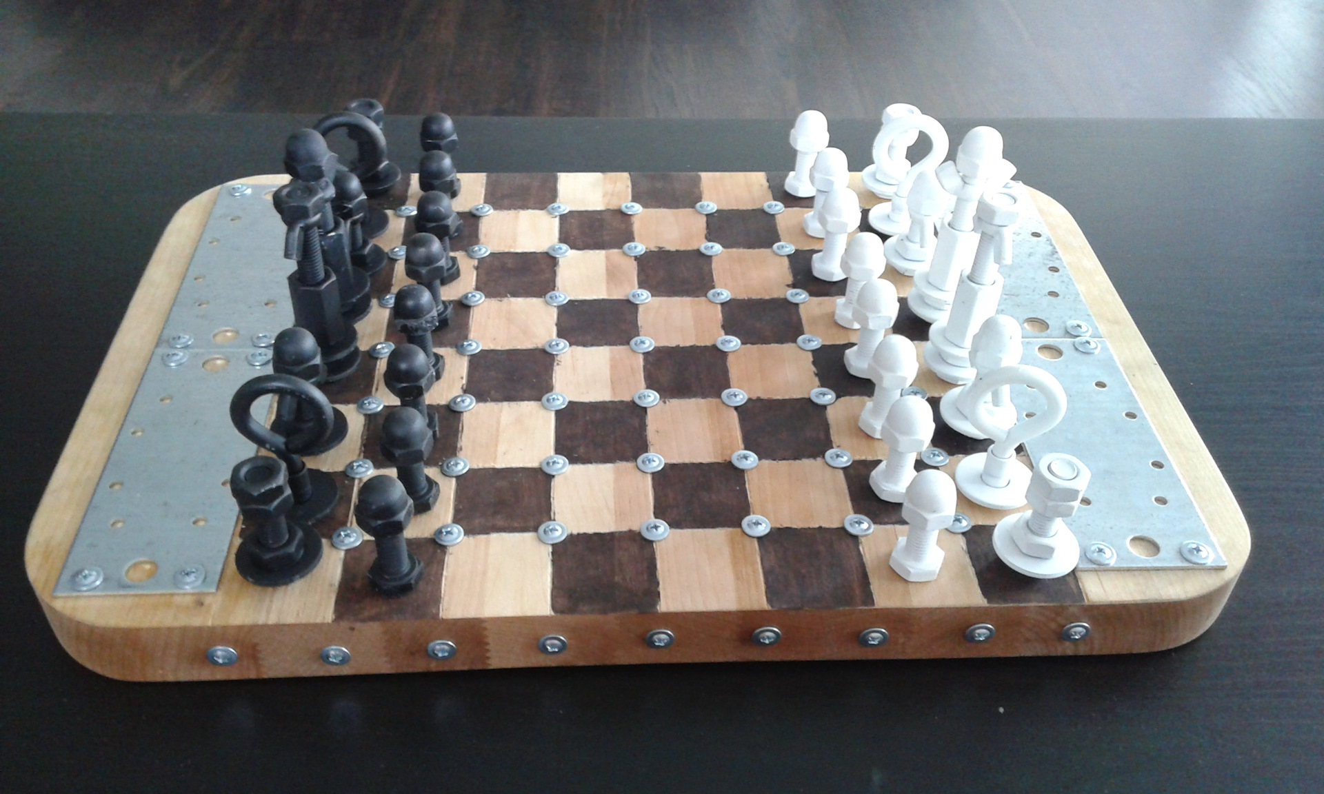 самодельные шахматы с недоигранной партией фигуры из гаек и болтов ввинчены в доску