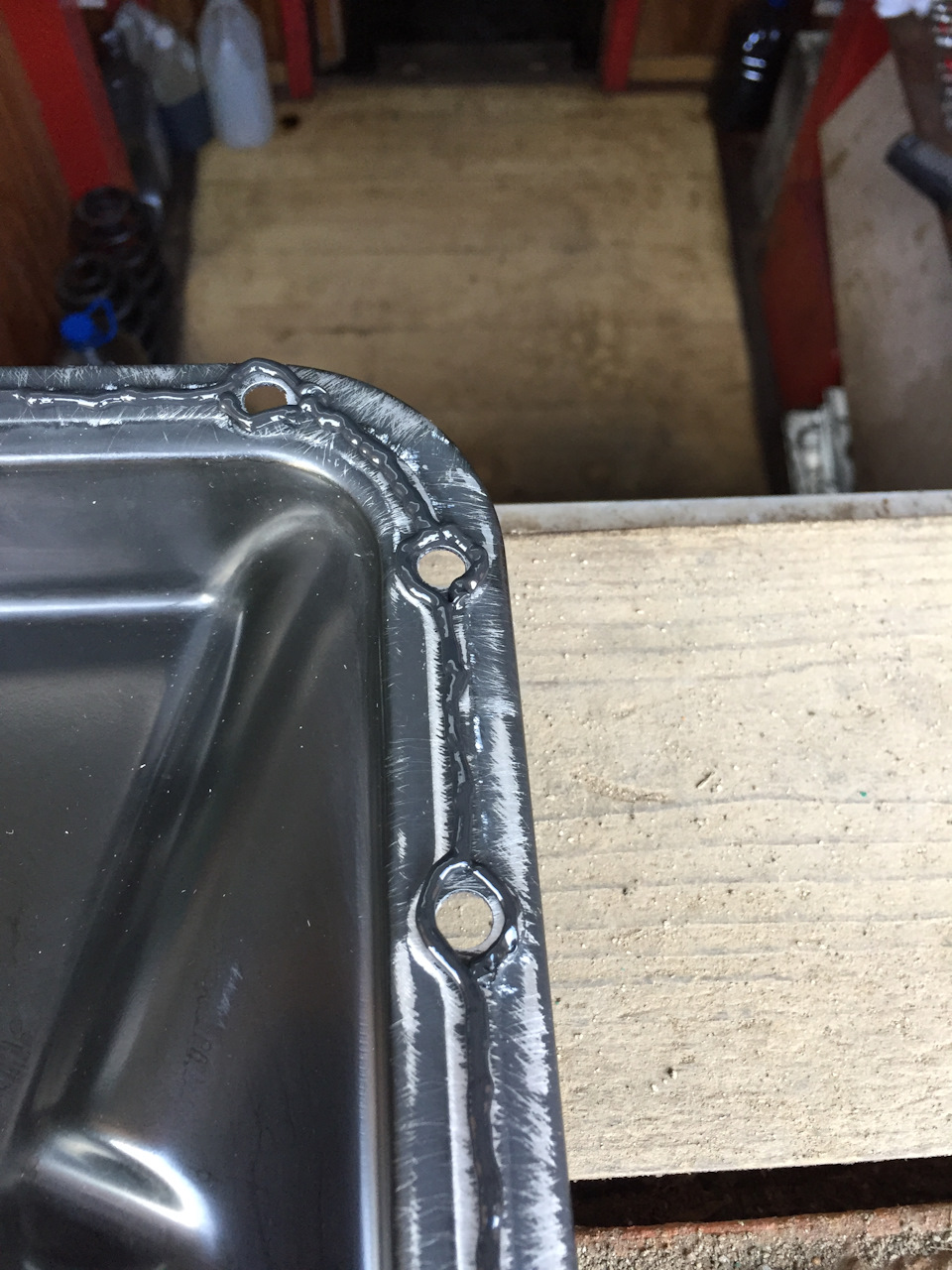 много герметика наносить не стоит, он может забить маслоприемник, валик обязательно должен огибать отверстия под болты по внутреннему краю, но так как на поддоне есть штампованная выпуклость наносим с двух сторон — Ford Focus Hatchback II