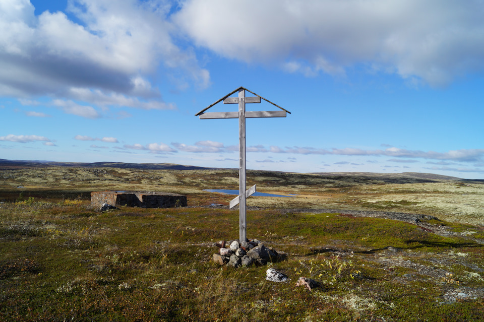 Православный крест у дотов, такие любят устанавливать местные священники во всех памятных местах и на возвышенностях. У подножия креста — остатки снарядов, касок, механизмов канатной дороги и пр. — Nissan Terrano III