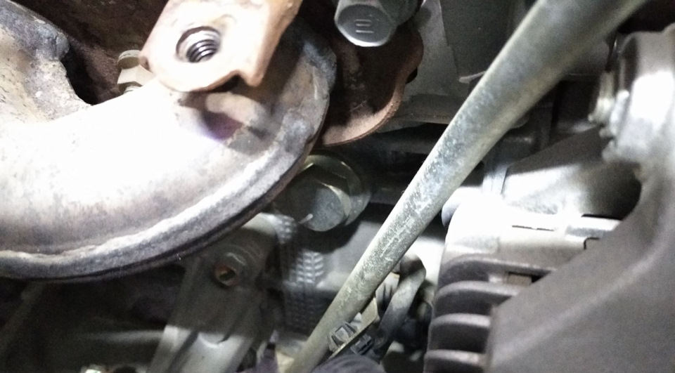 Сливная заглушка находится между выпускным коллектором и генератором — Mitsubishi Pajero Sport (3G)