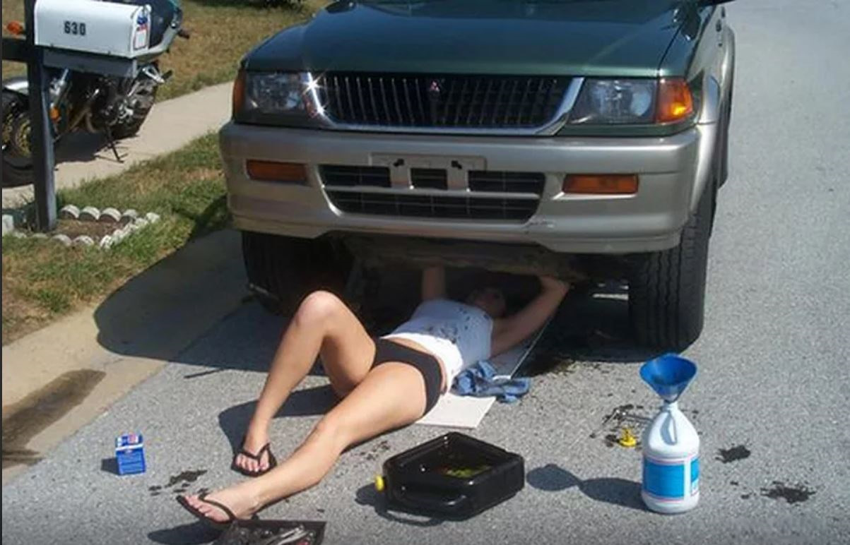 Починил девушке машину а она. Женщина под машиной. Девушка под машиной ремонтирует. Баба под машиной. Женщина чинит машину.