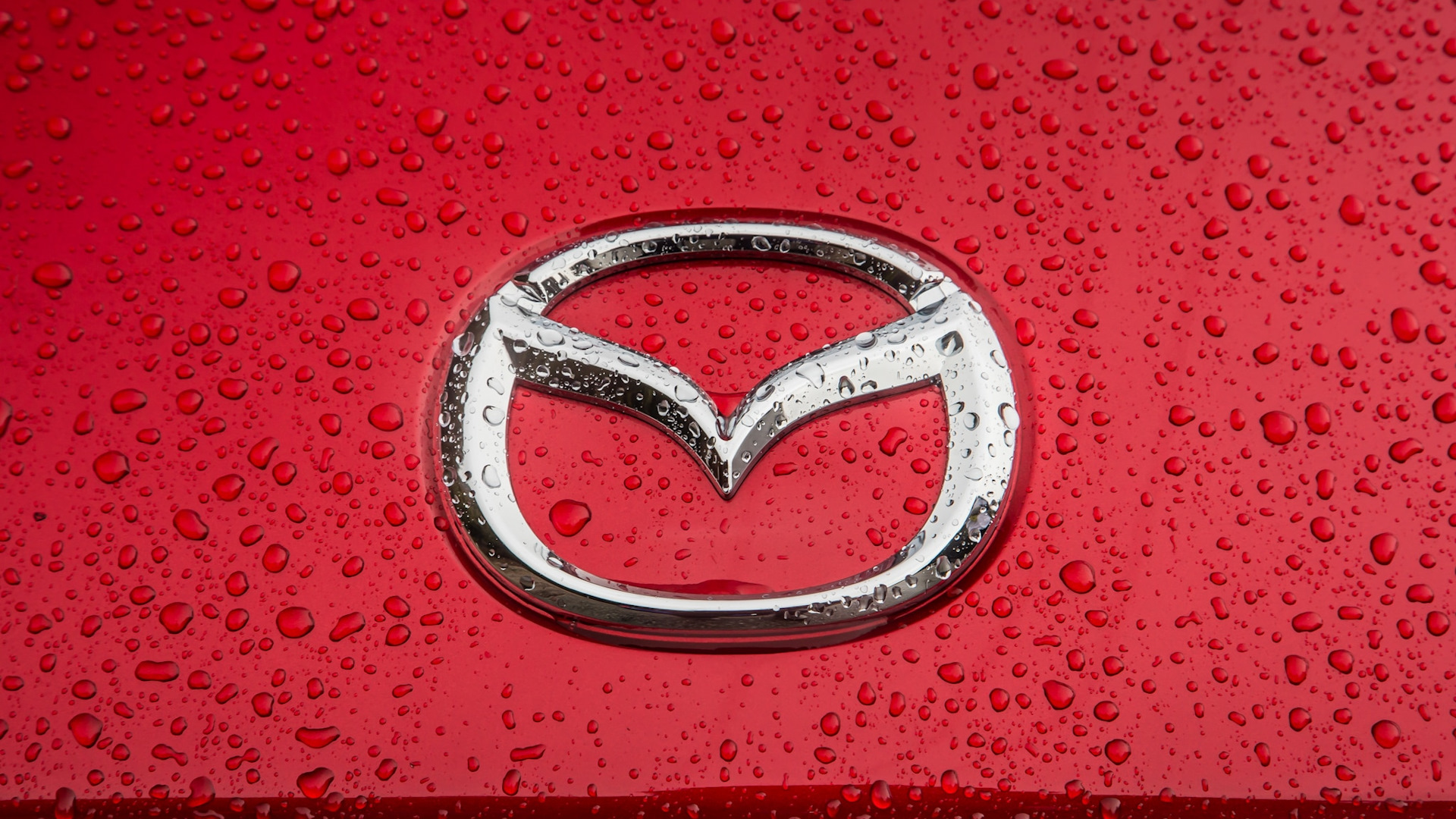 Что означает mazda. Mazda эмблема. Марка машины Мазда. Марки машин значки Мазда. Мазда символ.