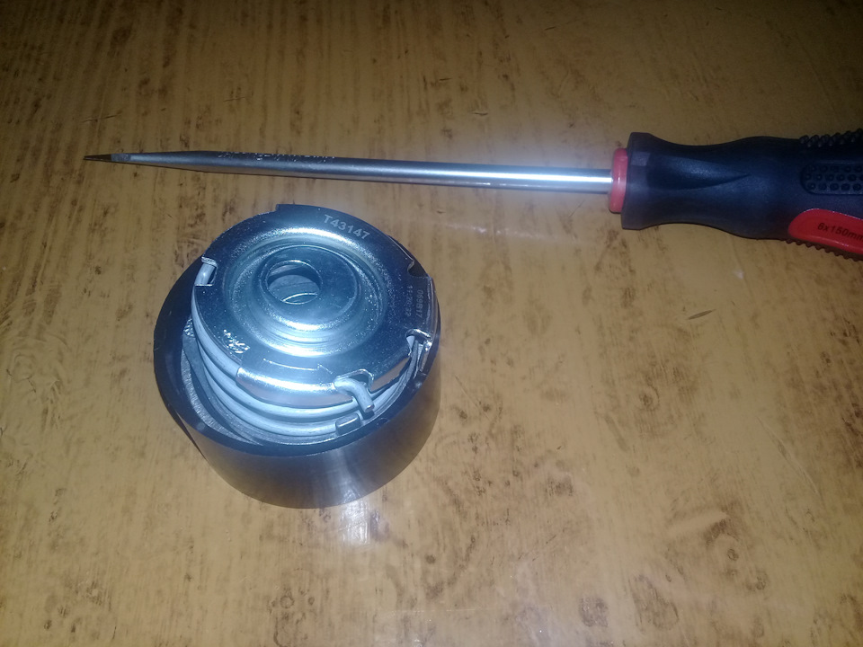 Поддев отверткой, снимаем крышку механизма натяжителя — Lada Granta. Запчасти на фото: T43147