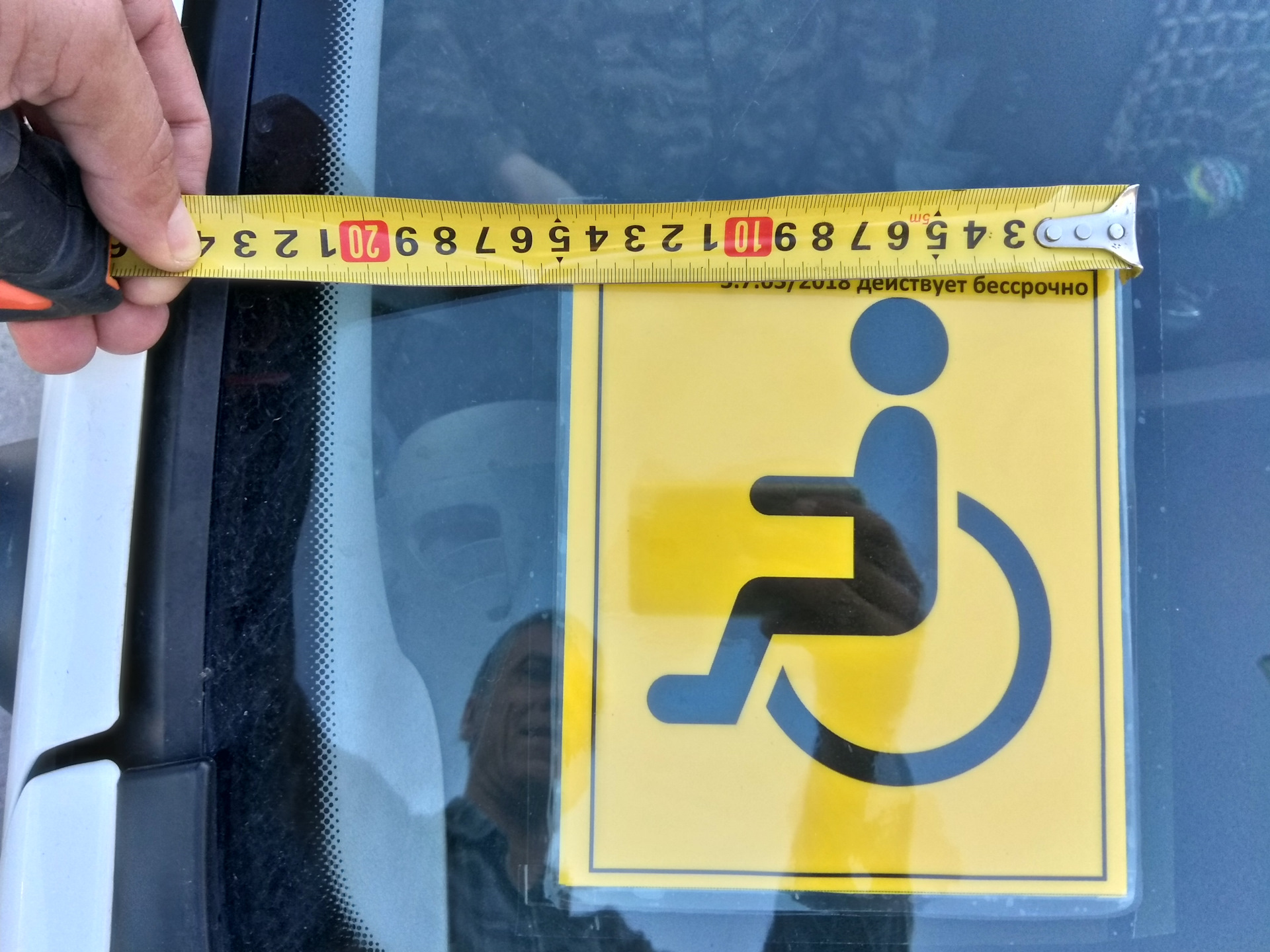 Автомобиль со знаком инвалид. Табличка инвалид на автомобиле. Знак инвалидная на автомоб. Наклейка инвалид для авто. Размер знака инвалид на машину.