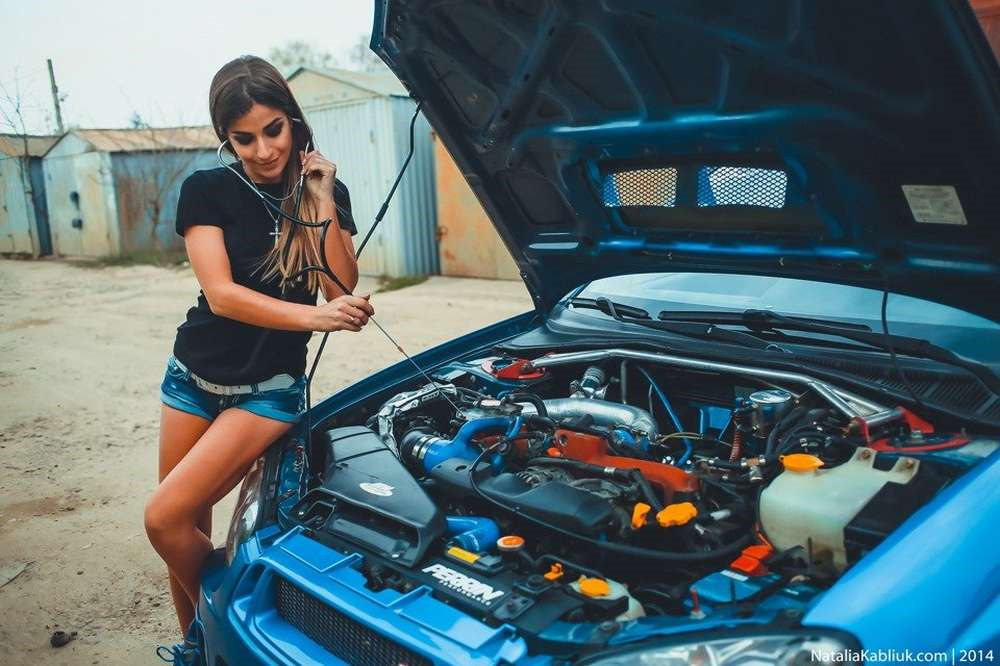 Похожим на женский капот. Девушка с открытым капотом авто. Девушка ремонтирует машину. Открытый капот машины. Девушка автослесарь.