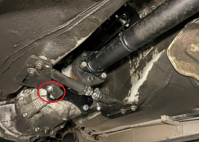 Что касается траверсы. Вернемся к ней. Состоит она из двух половинок. Так вот, после небольшого квеста этой запчасти, её удалось подогнать под кузов и закрепить. А вот коробка не вставала. Не задача. По правой стороне подушка встала как положено. А по левой подушка не встает в свое посадочное место. Крутили, вертели, так ничего и не придумали. Оказывается, была погрешность левой половинки траверсы. Если подогнать её под подушку, она не прикрутится к кузову. Ну и наоборот — подгоняешь под кузов, не бьет по подушке. По итогу подогнали траверсу под кузов и просверлить другое отверстие, чтоб закрепить подушку. Красным кружком обвел, где просверлил. Ничего сложного, но на это мы потратили не мало времени. — Toyota Altezza