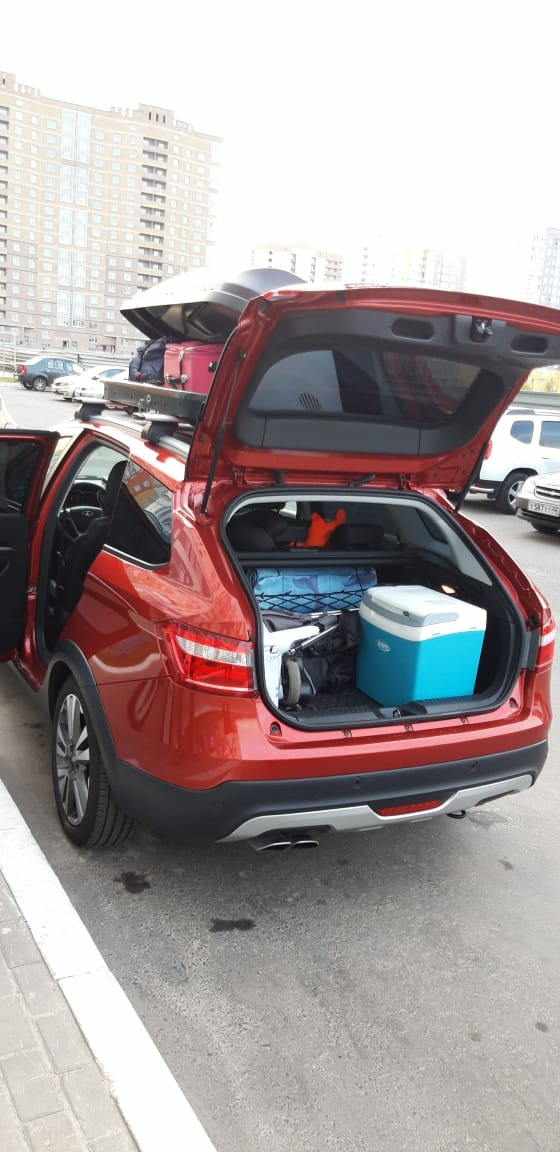 В багажнике холодильник, детская коляска, запас еды и воды, мелкие пакеты — Lada Vesta SW Cross (1G)