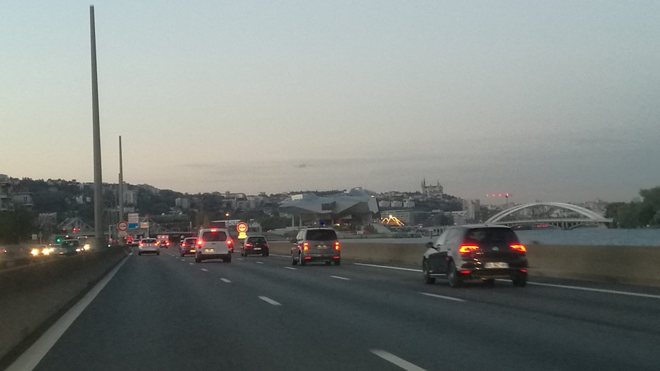 Всвязи с переходом на зимнее время сумерки наступают на час раньше. Впереди виднеется футуристичный музей Конфлюанс (musée de Confluence) и базилика Нотр-Дам де Фурвьер (Notre-Dame de Fourvière). — Audi A4 (B9)