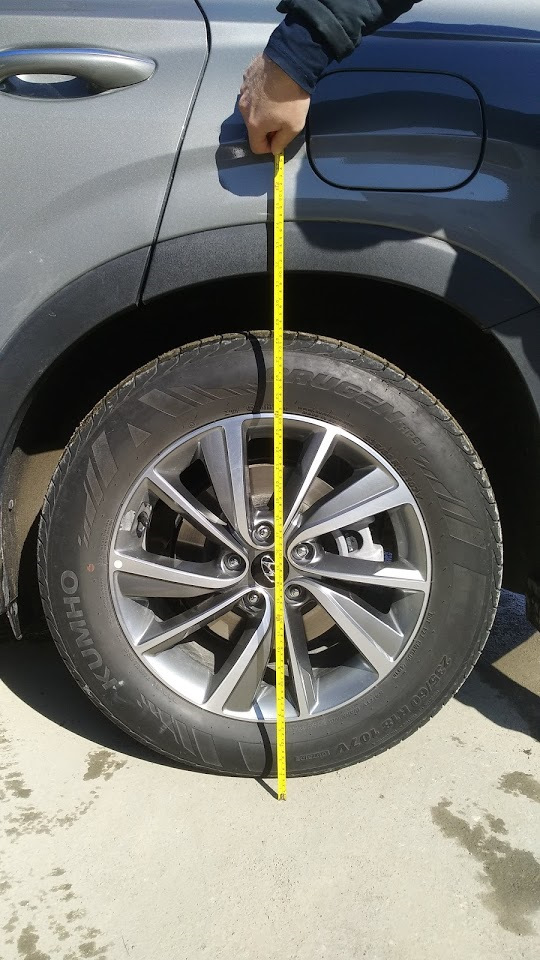 11. Przód: włóż kolumnę z podkładką do kielicha; złap nakrętkami, osadź w zwrotnicy i dokręć obejmę. — Hyundai Santa Fe TM