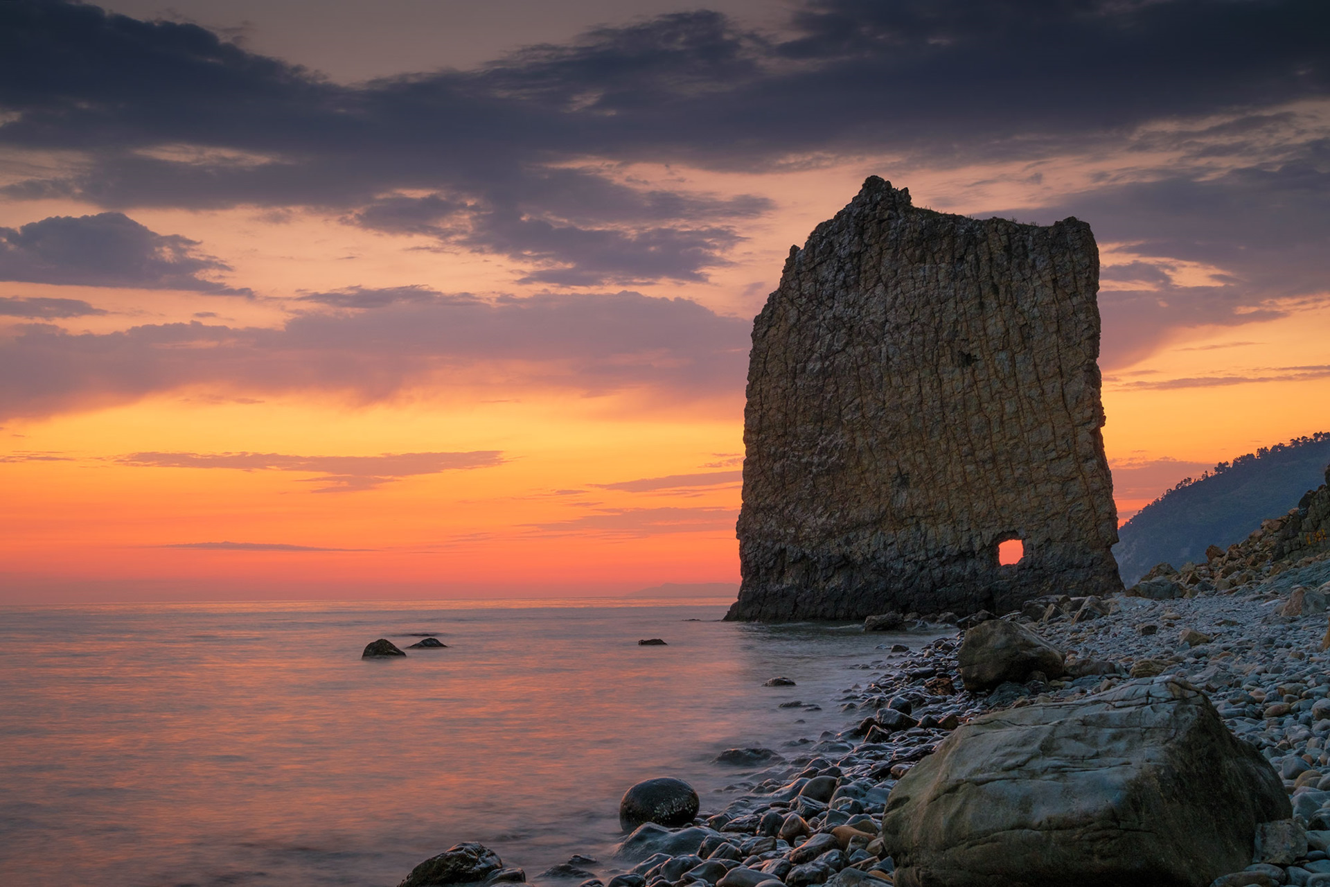 Боковой вид на скалу Парус, где чётко видно большое отверстие в центре каменной плиты
