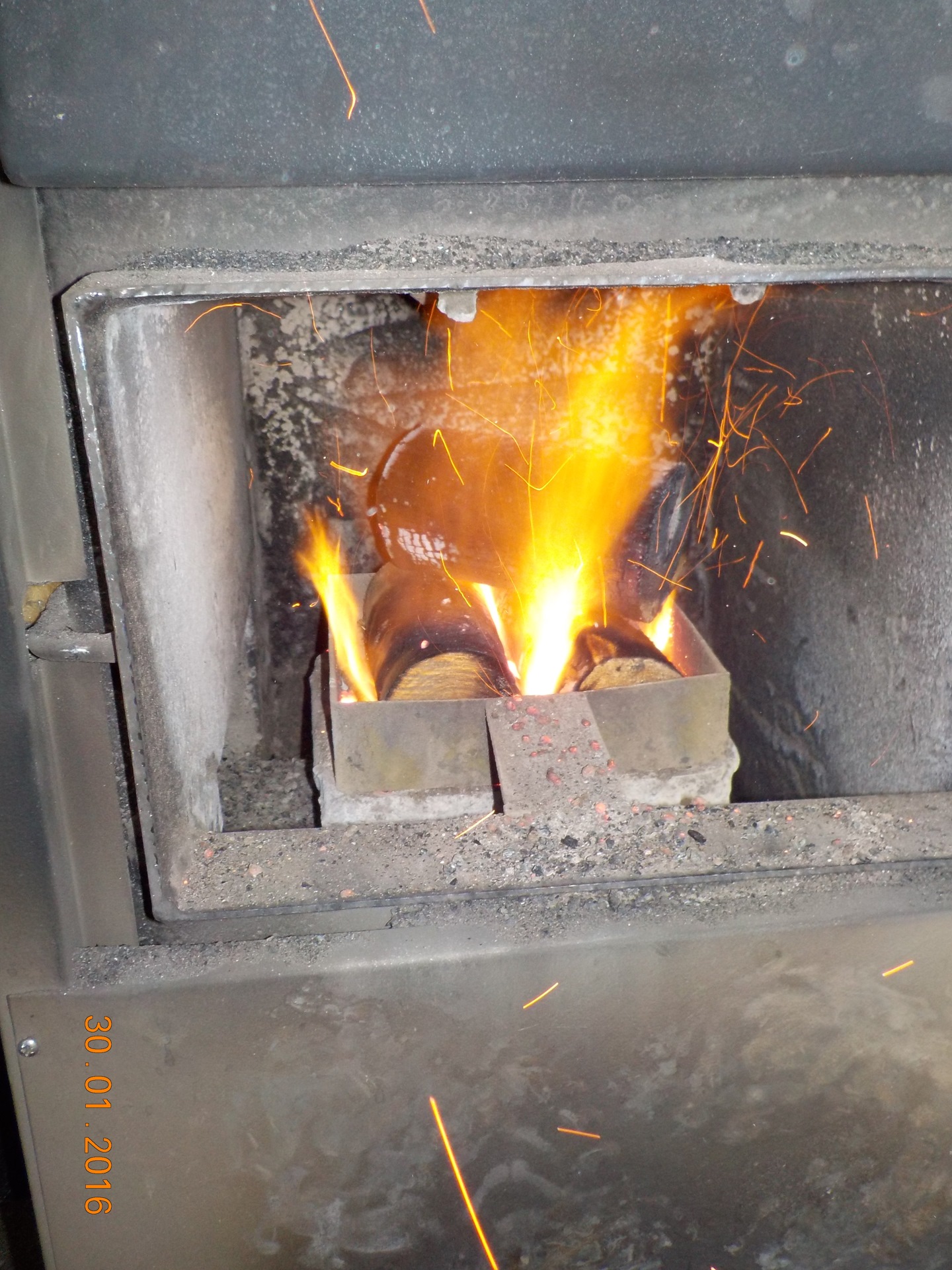 Топка печки брикетами. Печь топится гранулами пеллетами. Печь на дровах. Топится печь. Пеллетная горелка в железную печь.