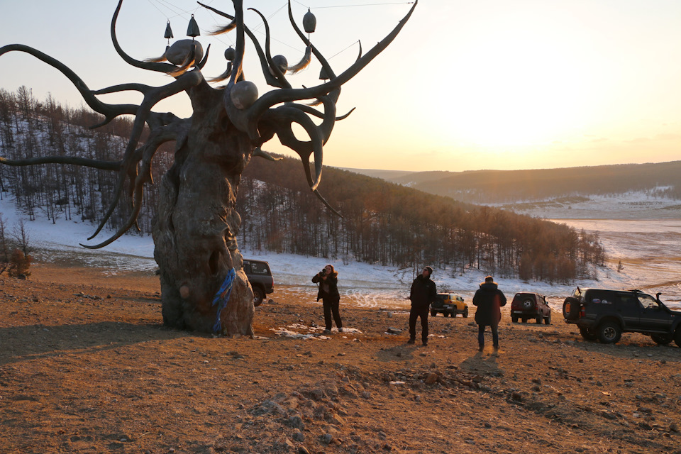 Удачное место выбрали для Хранителя. Стоит на сопке, ветрами продуваемый, негромко и мелодично звенят какие-то бубенчики или колокольчики (не знаю как правильно называются). Практически сразу за ним обрыв, крутой и высокий, внизу плещется Байкал. — Toyota Land Cruiser 80