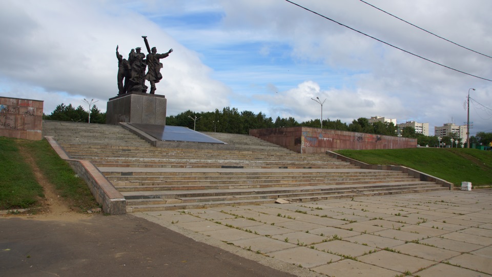 Комсомольск на амуре летом. Набережная Комсомольска на Амуре памятник. Памятник на набережной в г. Комсомольске на Амуре. Памятник первостроителям Комсомольск. Памятник на набережной в Комсомольске первостроителям.