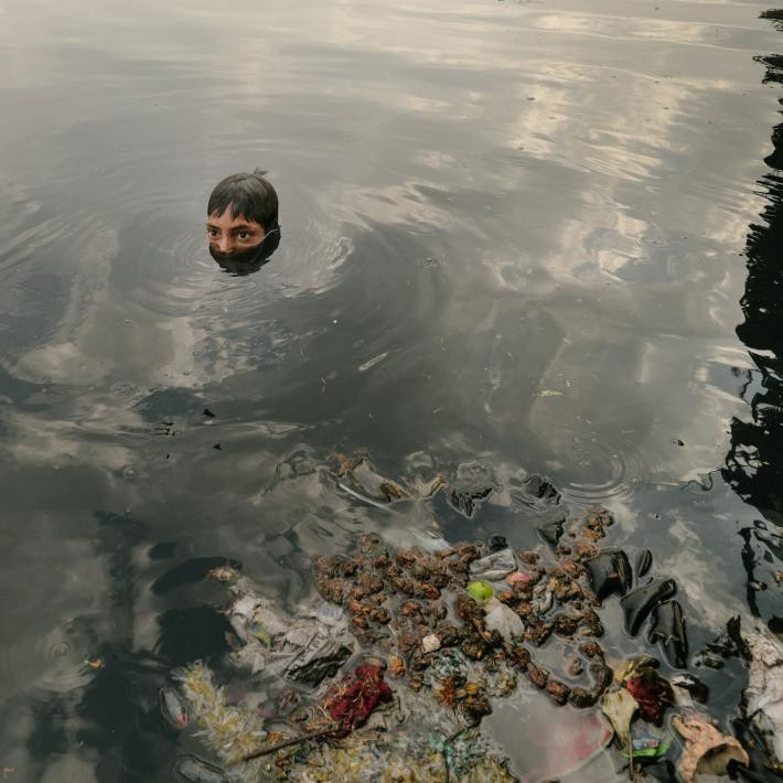 Мутный водоем. Люди купаются в грязной воде. Купание в загрязненных водоемах.