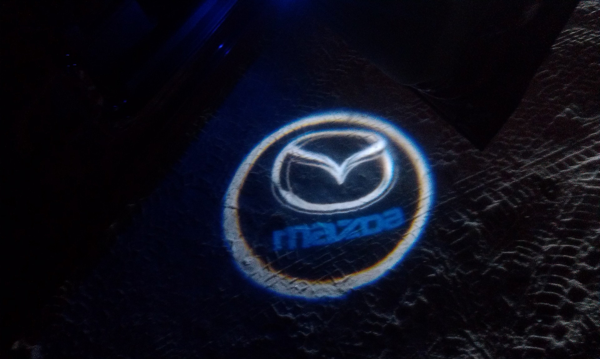 Проекция мазда. Мазда МПВ подсветка в дверь. Mazda 3 с проекцией. Renault 2021 проекция логотипа.