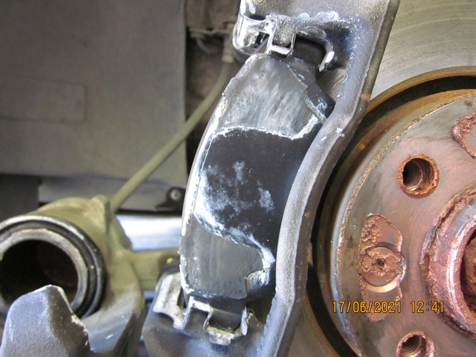 Передний тормоз, вид с откинутым суппортом, крупный план. В центре большую часть пасты смыло струёй Херкера; по бокам (в зазоре между колодкой и скобой) паста перемешалась с продуктами износа отчего несколько загустилась — Lada Vesta SW (1G)