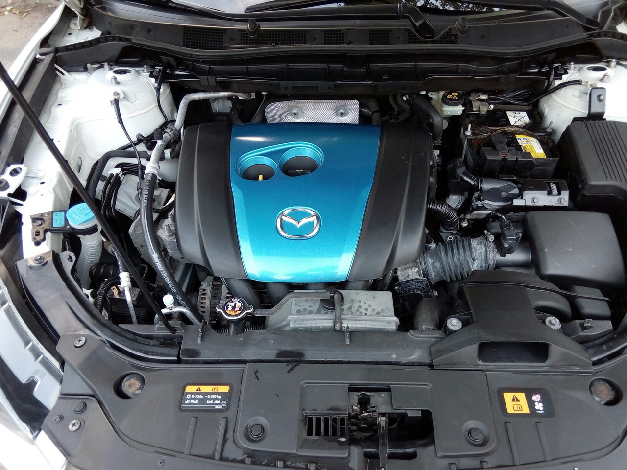 Мазда сх5 двигатель 2. Mazda CX 5 под капотом. Mazda CX 5 подкапотное пространство. Подуопотная пространство Mazda CX-5. Mazda CX 9 подкапотное пространство.