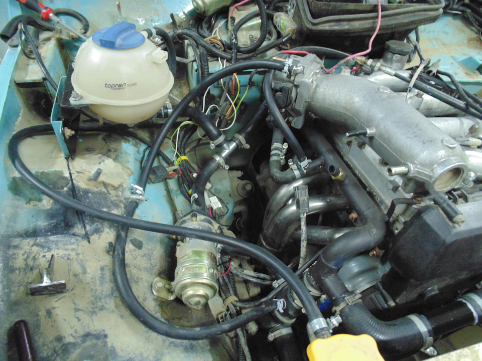 Монтаж системы охлаждения, расширительный бачок в очередной раз переезжает. Подключен через тройник к обратке печки. Патрубок от Клубтурбо коротковат оказался и верхний патрубок радиатора пришлось соединить куском обводной трубы Приоры. Так даже лучше получилось-нет длинного шланга, всё компактно. — Lada 4x4 3D