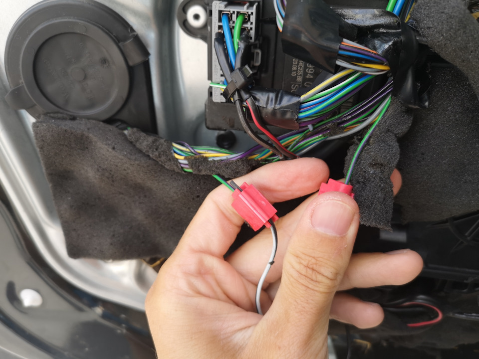 Далее переходим к жгуту проводки рядом с модулем управления дверью. Вытаскиваем и перекусываем провод отвечающий за сигнал от замка к CEM (зелено-фиолетовый в случае водительской двери). У меня тут уже подключена проводка от другого модуля — не обращайте внимания. — Volvo XC70 III