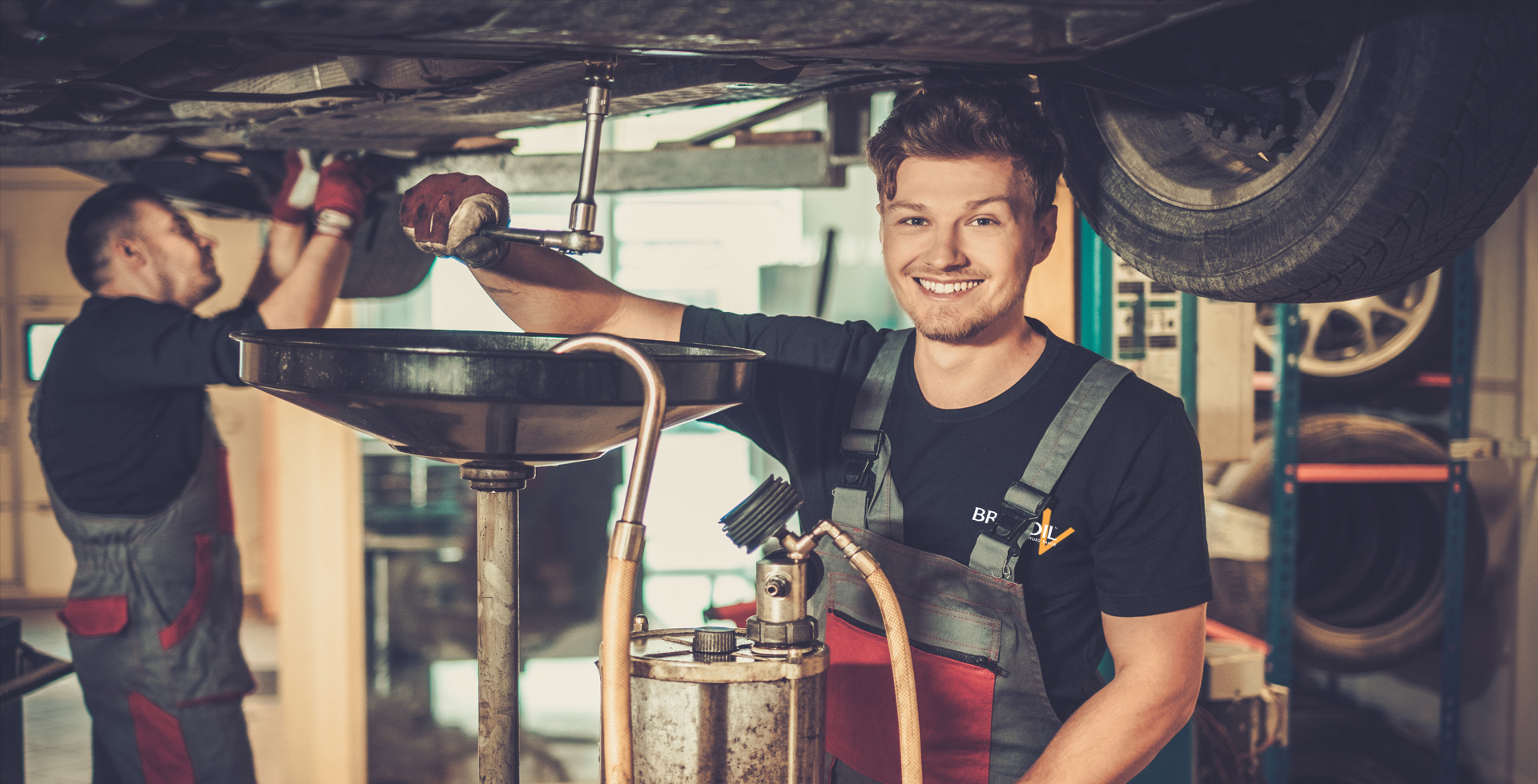 Механик масла. Механики маслопуки. Photo of an Oil change in a car service Station.